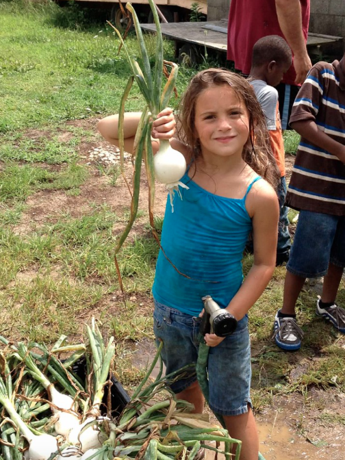 Abby holding White Onion at HeartBeet Farms